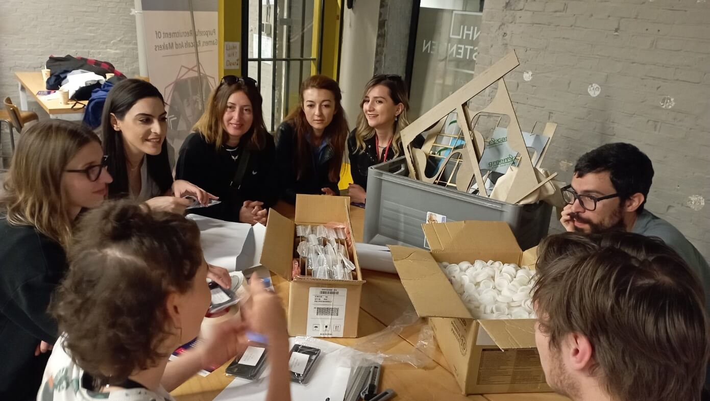People gathered around a table filled with building materials