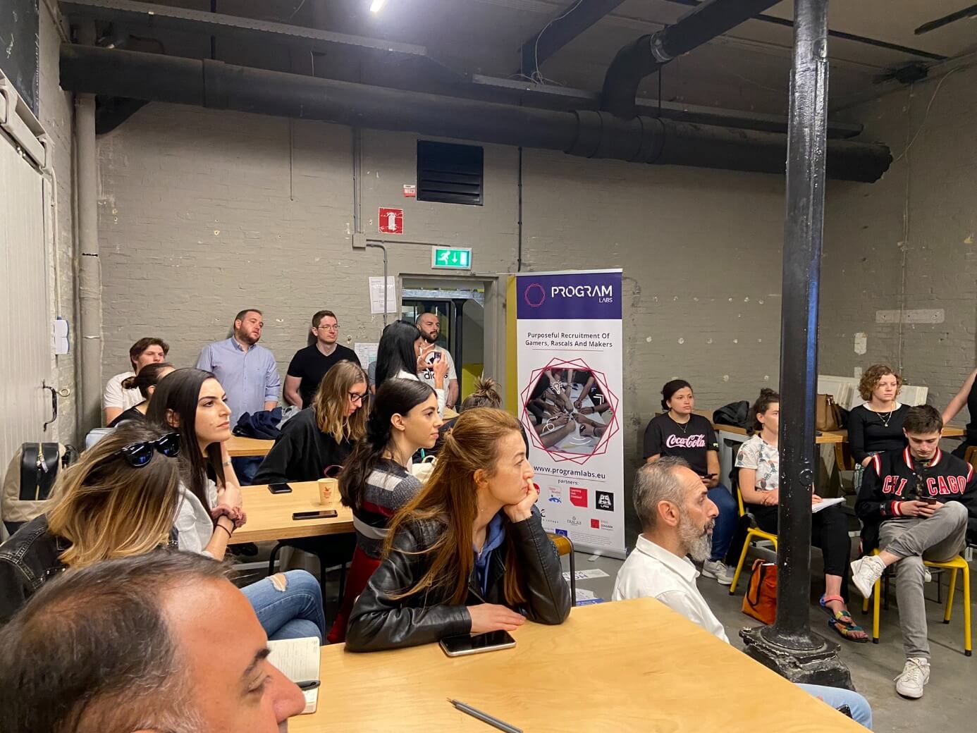 People sitting in a room listening to someone talk